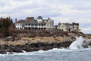 Large vacation home overlooking waves crashing on rocky shore in York, Maine